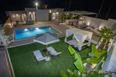 an overhead view of a backyard with a swimming pool and lawnitures at Melia Luxury Villa in Kolimbia