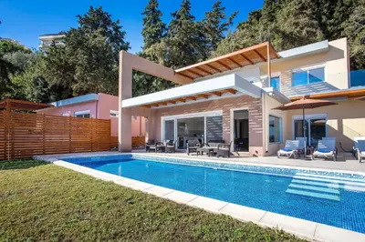 a villa with a swimming pool and a house at Louloudi Hills Villa 1 in Koskinou