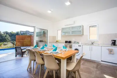 a kitchen and dining room with a table and chairs at Louloudi Hills Villa 1 in Koskinou