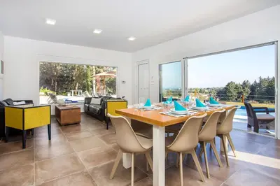 a dining room with a table and chairs at Louloudi Hills Villa 1 in Koskinou