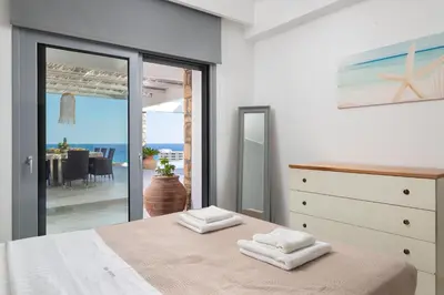 a bedroom with a bed and a view of the ocean at Modern Luxury Villa in Rhodes Town