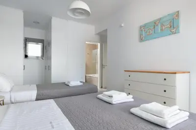 a bedroom with two beds and a dresser with towels at Modern Luxury Villa in Rhodes Town