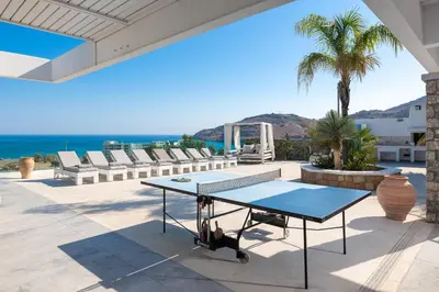 a ping pong table on a patio overlooking the ocean at Modern Luxury Villa in Rhodes Town