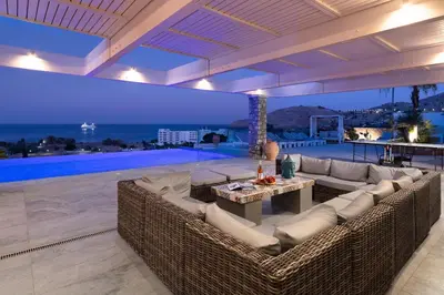 a living room with wicker furniture and a swimming pool at Modern Luxury Villa in Rhodes Town