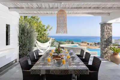 a dining table on a patio with a view of the ocean at Modern Luxury Villa in Rhodes Town