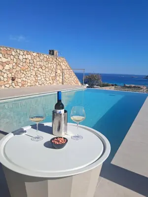 a table with two glasses and a bottle of wine at Villa Mare di Levante with Private Pool in Líndos