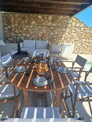 a wooden table and chairs on a patio at Villa Mare di Levante with Private Pool in Líndos