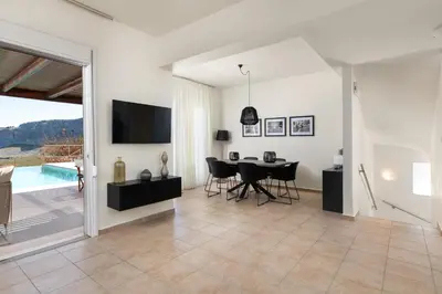 a living room with a dining room table and a tv at Villa Mare di Levante with Private Pool in Líndos