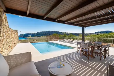 a patio with a table and chairs and a swimming pool at Villa Mare di Levante with Private Pool in Líndos