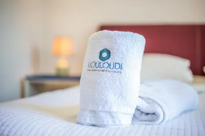 a stack of towels sitting on top of a bed at Louloudi Hills Villa 2 in Koskinou