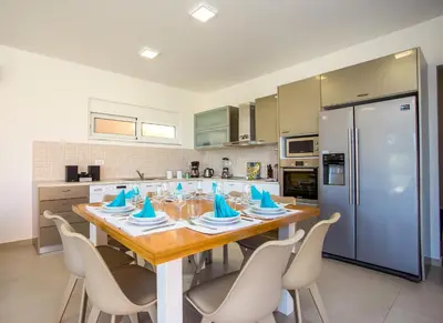 a kitchen with a large wooden table and chairs at Louloudi Hills Villa 2 in Koskinou