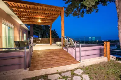 a wooden boardwalk leading up to a house at Louloudi Hills Villa 2 in Koskinou