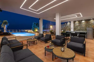 a living room with a couch and chairs and a pool at Vitzi Vista Villa in Rhodes Town