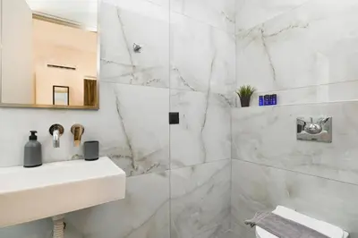a white bathroom with a sink and a shower at Villa Zen Roshi by Villa Plus in Kolimbia