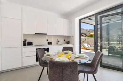 a kitchen and dining room with a table and chairs at Villa Zen Roshi by Villa Plus in Kolimbia