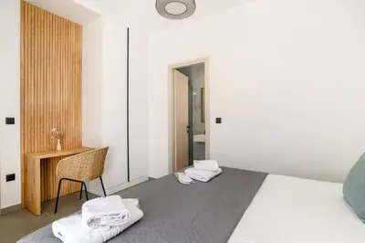 a bedroom with a bed and a desk with towels at Villa Zen Roshi by Villa Plus in Kolimbia