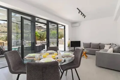 a living room with a table and chairs and a couch at Villa Zen Roshi by Villa Plus in Kolimbia