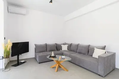 a living room with a gray couch and a table at Villa Zen Roshi by Villa Plus in Kolimbia