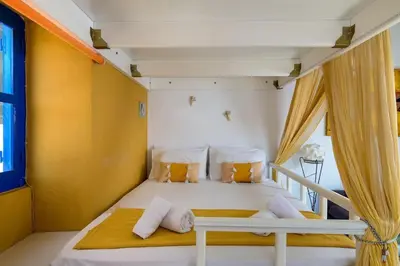 a white bed in a room with a window at Yellow Oasis traditional home with sea view in Halki