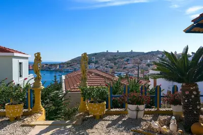 a garden with potted plants and a view of a city at Yellow Oasis traditional home with sea view in Halki