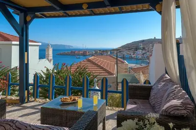 a patio with a table and a view of the water at Yellow Oasis traditional home with sea view in Halki