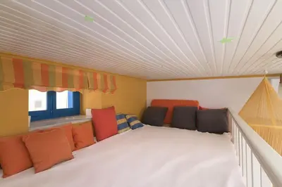 a room with orange and black pillows and a ceiling at Yellow Oasis traditional home with sea view in Halki