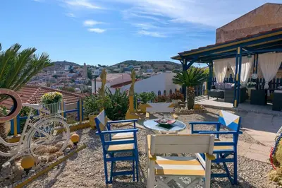 a patio with chairs and a table on a roof at Yellow Oasis traditional home with sea view in Halki
