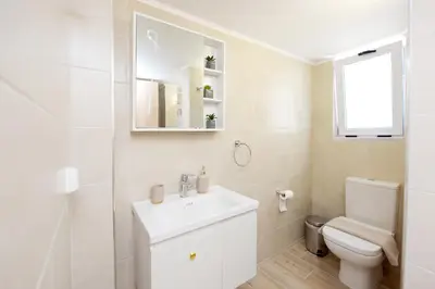 a white bathroom with a sink and a toilet at Square home in Émbonas