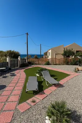 a patio with two lawn chairs and the ocean at Blue waves house 1 in Rhodes Town