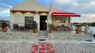 a house with a red awning and a patio at Blue waves house 1 in Rhodes Town