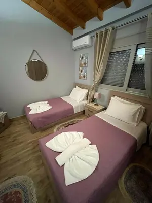 two beds in a room with purple sheets at Blue waves house 1 in Rhodes Town