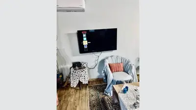 a living room with a chair and a flat screen tv at Blue waves house 1 in Rhodes Town