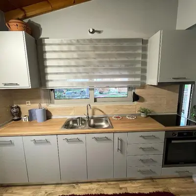 a kitchen with white cabinets and a sink and a window at Blue waves house 1 in Rhodes Town