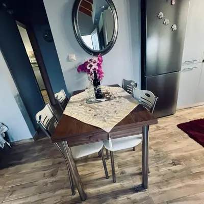a dining room table with a vase of flowers on it at Blue waves house 1 in Rhodes Town