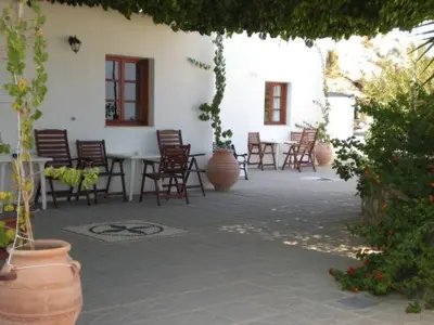 a patio with chairs and a table and a building at Chrysa Studios in Líndos