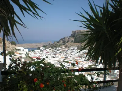 a view of a town from a palm tree at Chrysa Studios in Líndos