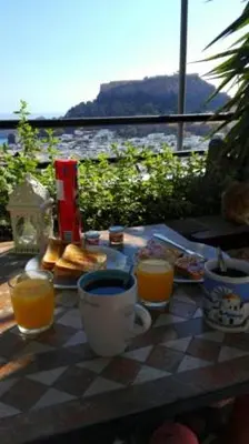 a table with two cups of coffee and orange juice at Chrysa Studios in Líndos