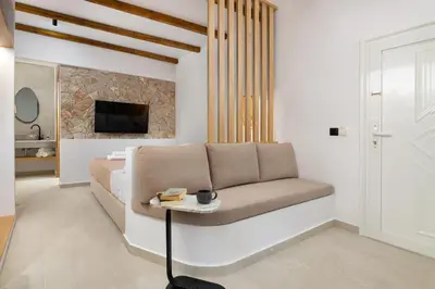 a living room with a couch and a tv at Onar Luxury Suites - Jacuzzi Terrace in Archangelos
