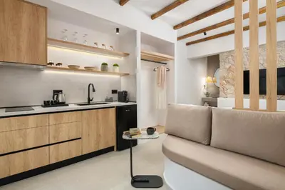a living room with a couch and a kitchen at Onar Luxury Suites - Jacuzzi Terrace in Archangelos
