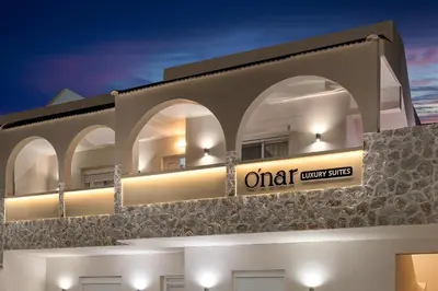 a building with a sign on the side of it at Onar Luxury Suites - Jacuzzi Terrace in Archangelos