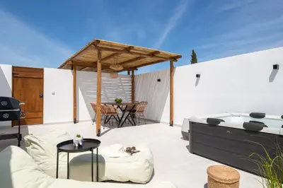 an outdoor patio with a table and chairs at Onar Luxury Suites - Jacuzzi Terrace in Archangelos