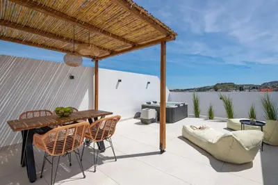 a patio with a wooden table and chairs at Onar Luxury Suites - Jacuzzi Terrace in Archangelos
