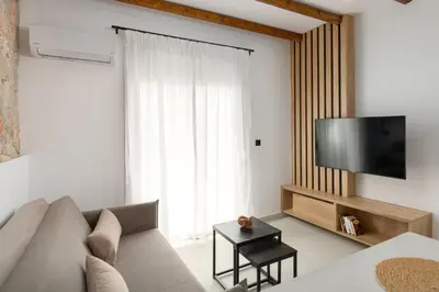 a living room with a couch and a flat screen tv at Onar Luxury Suites - Jacuzzi Terrace in Archangelos