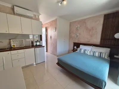 a large bedroom with a bed and a kitchen at Ninas Room in Rhodes Town