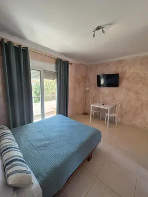 a bedroom with a bed and a table and a television at Ninas Room in Rhodes Town