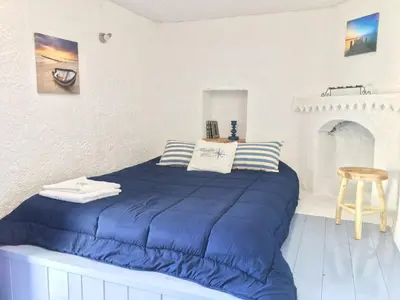 a bedroom with a large blue bed with pillows at Rhodes Summer House in Gennadi
