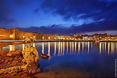 a large body of water with a city at night at 3 Charites Old Town in Rhodes Town
