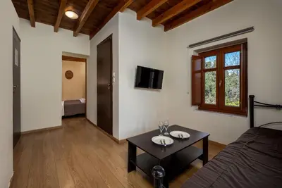 a room with a bed and a table and a tv at 3 Charites Old Town in Rhodes Town