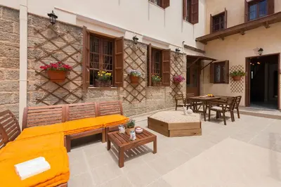 a patio with a couch and tables and a building at 3 Charites Old Town in Rhodes Town