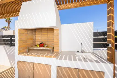a white house with a fireplace on a balcony at Villa Salty Sun 1 in Kremasti